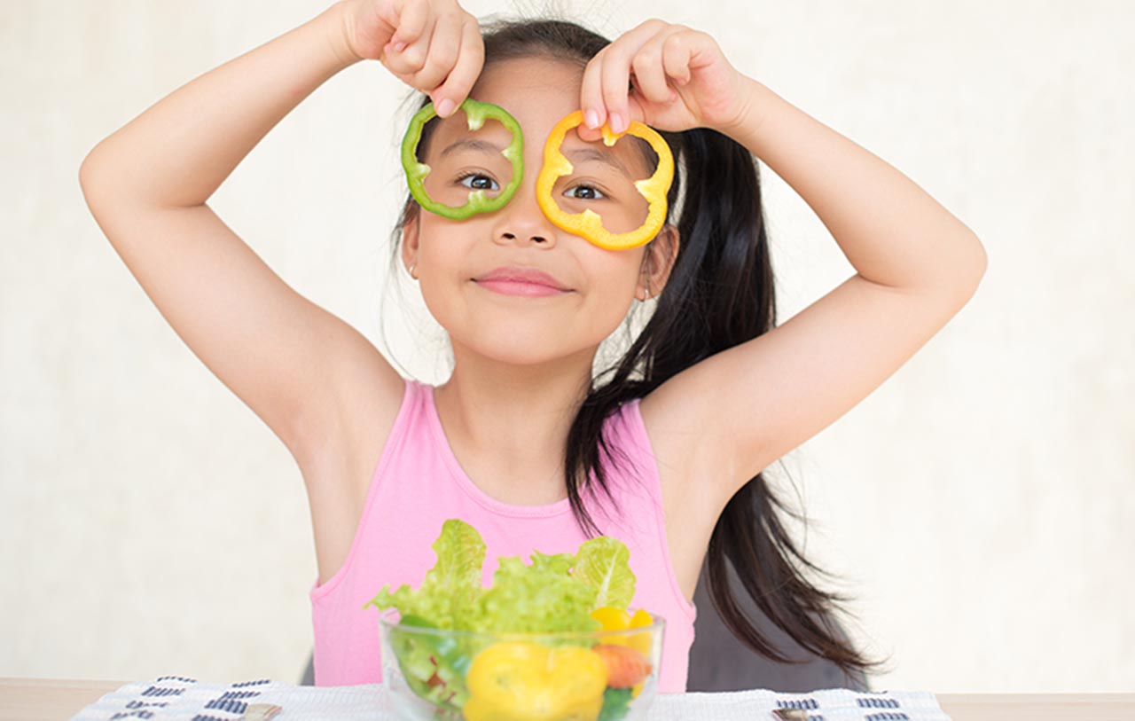 little asian girl enjoy eating with vegetable salad with bowl in